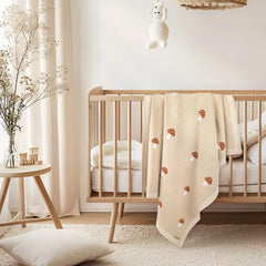 Pinuotu mushroom baby blanket draped on crib for everyday comfort.