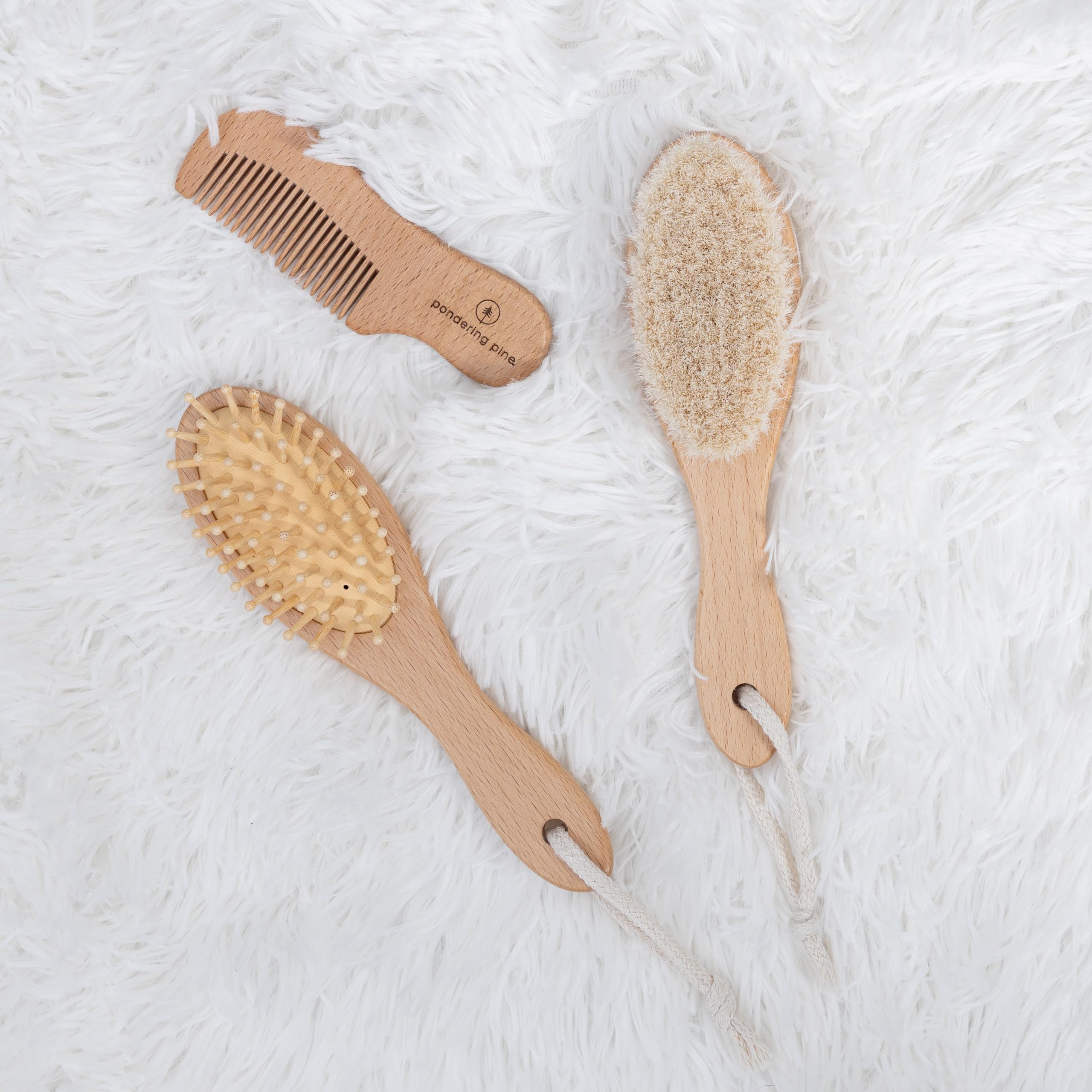 Pondering Pine newborn hairbrush for scalp massage and oil distribution.