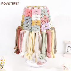 POVETIRE baby accessory organizer rack showcasing clips, bows, and headbands.