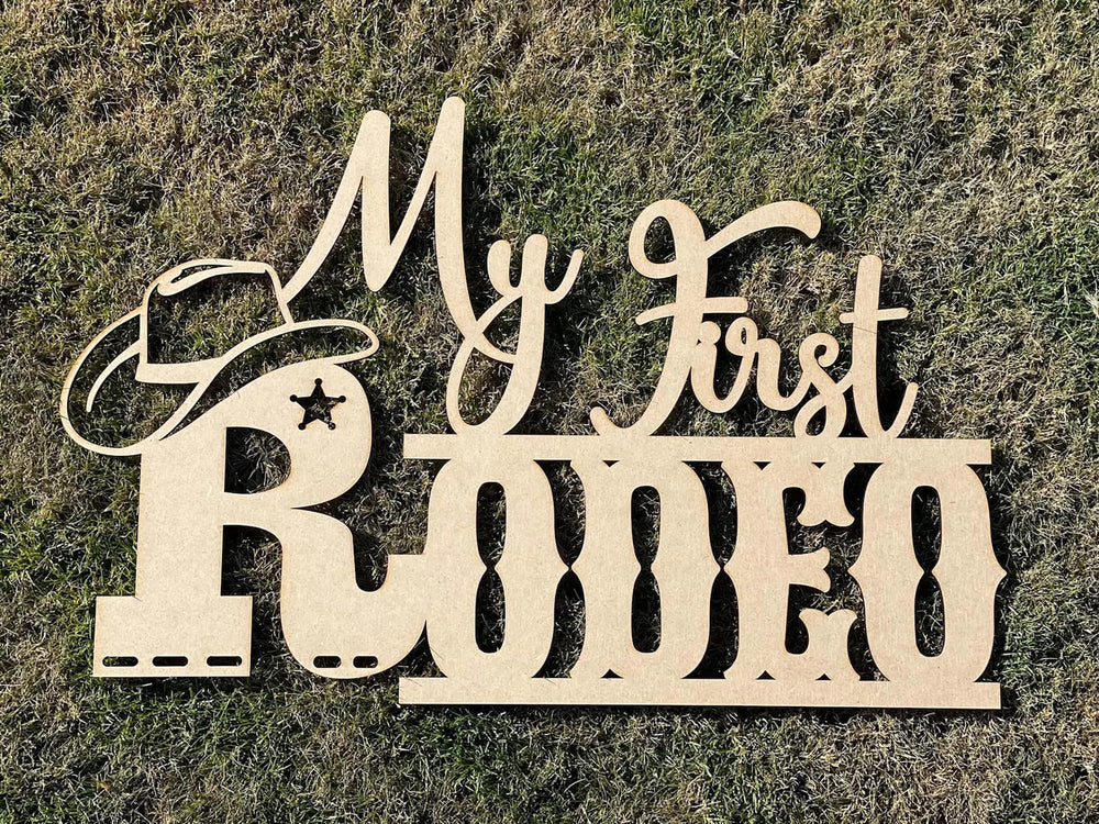 QPARTYFIRE My First Rodeo Sign front view, warm wooden backdrop ideal for photos.