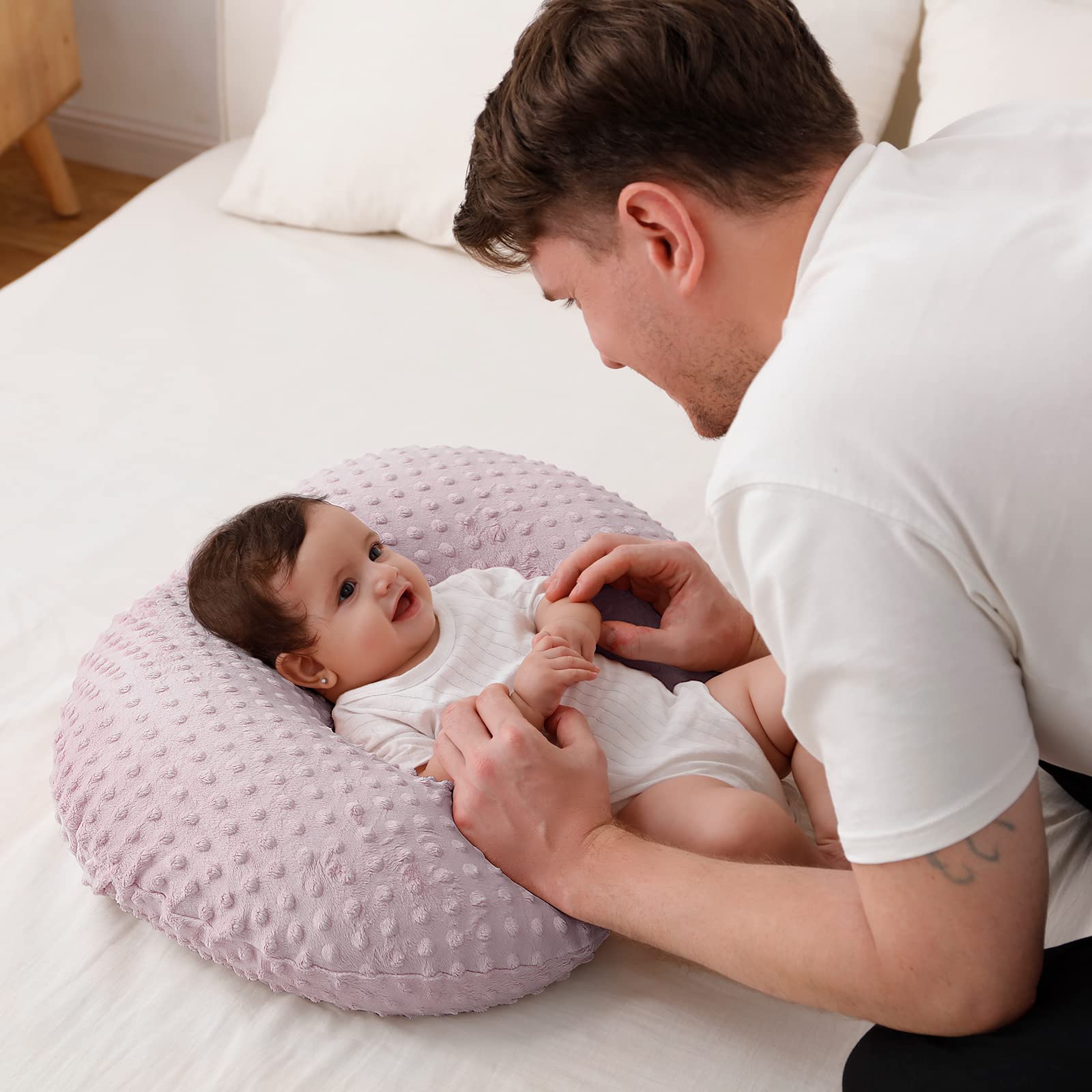 Queness Baby infant nursing pillow designed for tummy time and positioning.