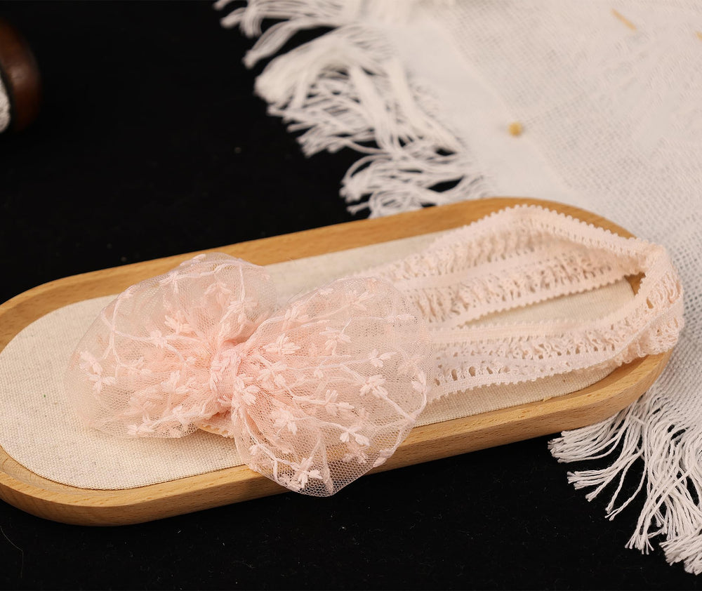 Rannyrena lace bow headband in ivory provides elegant accessory for special occasions.