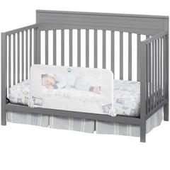 Salcod universal swing-down crib rail guard in white shown on a standard crib barrier
