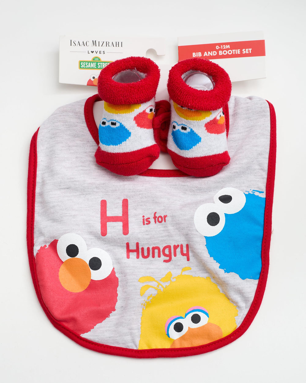 Baby wearing Sesame Street set during mealtime, cheerful scene.