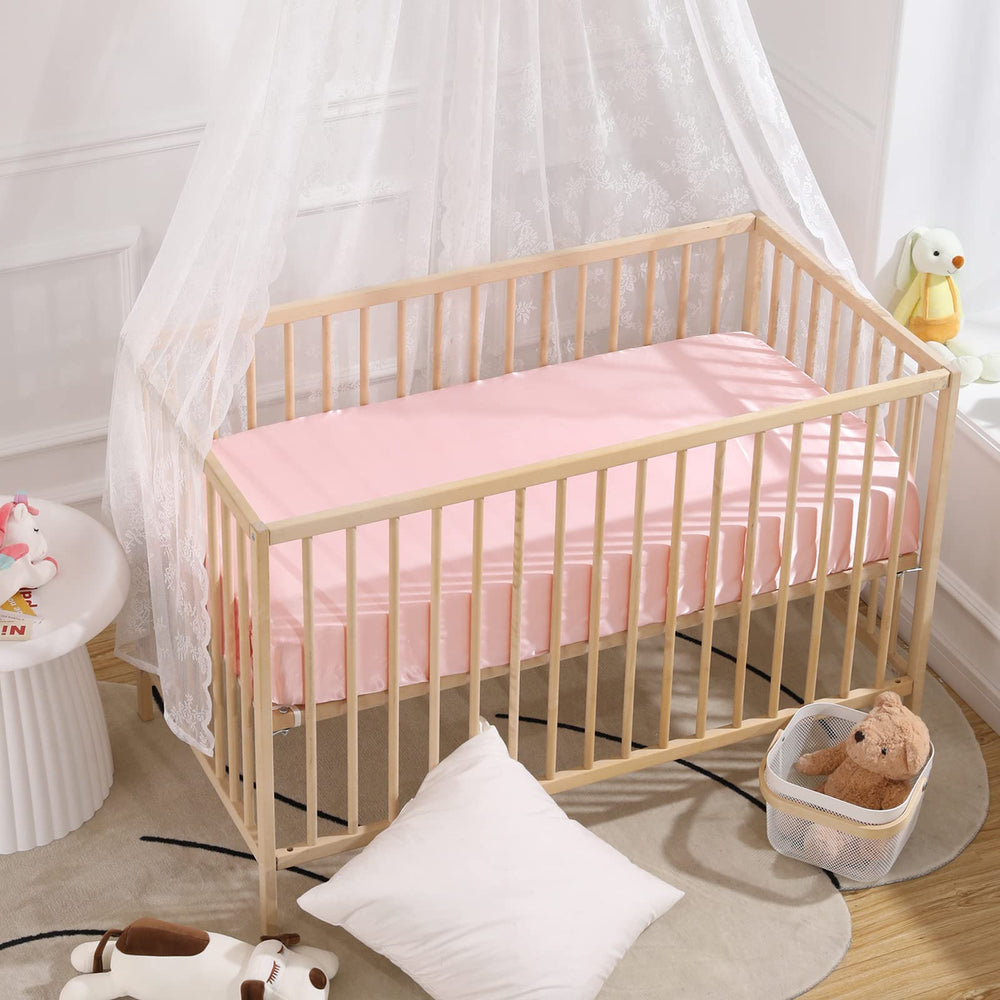 Closeup of satin mini crib sheet showing pack n play compatibility