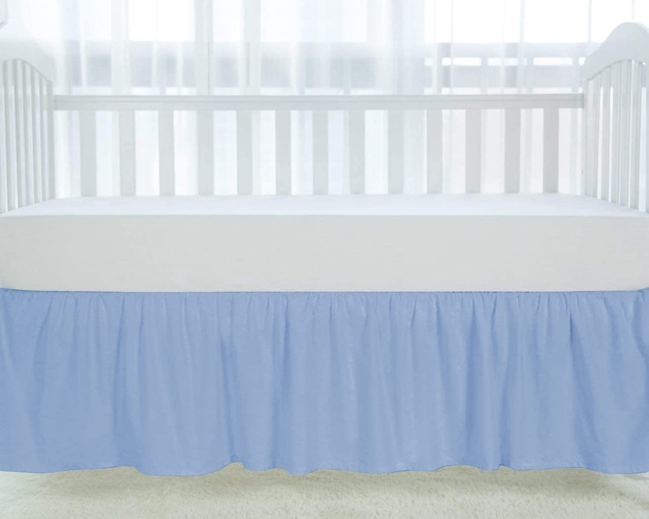 Silentnight light blue crib skirt shows elegant ruffles around the crib posts.