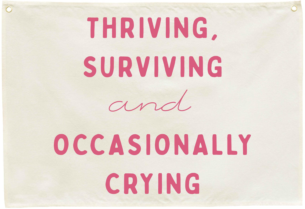 Sioial Thriving Surviving beige banner; easy to hang above crib.