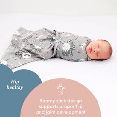 Baby sleeps peacefully in SleepingBaby Zippy Swaddle in a calm nursery.