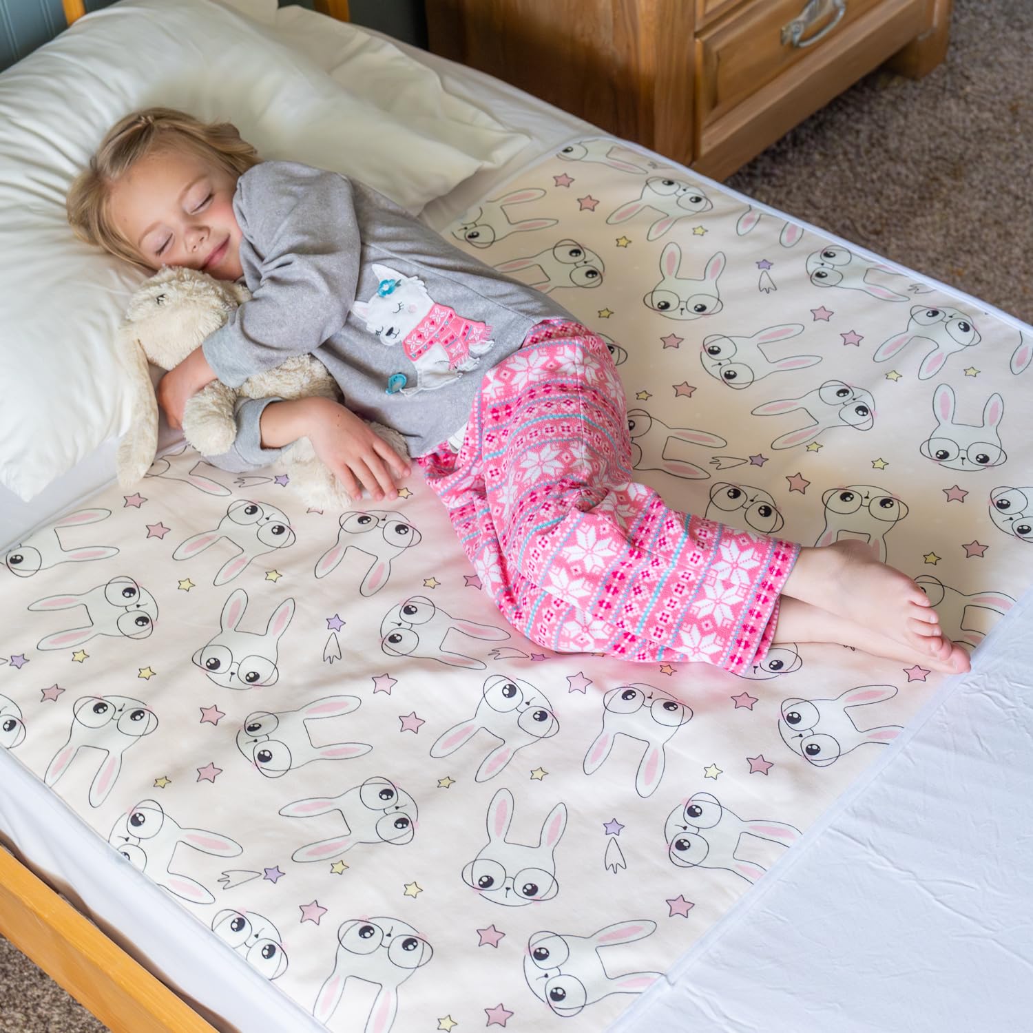 Snugglekid tuckable side bed pad with pink bunny print protects mattress during potty training nights.