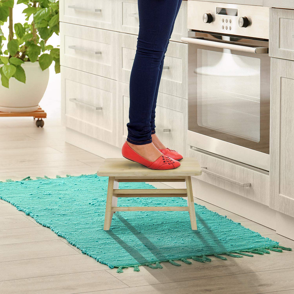 Sorbus Bamboo Step Stool beside a bed as a convenient footrest