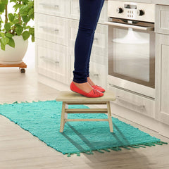 Sorbus Bamboo Step Stool beside a bed as a convenient footrest