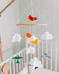 Sorrel + Fern matching garland enhances rainbow mobile decor above crib