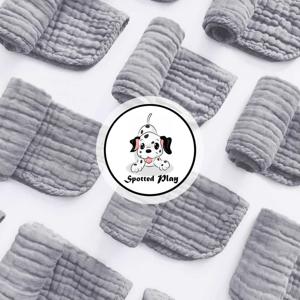 Spotted Play grey muslin burp cloth with reinforced edges and high absorbency.