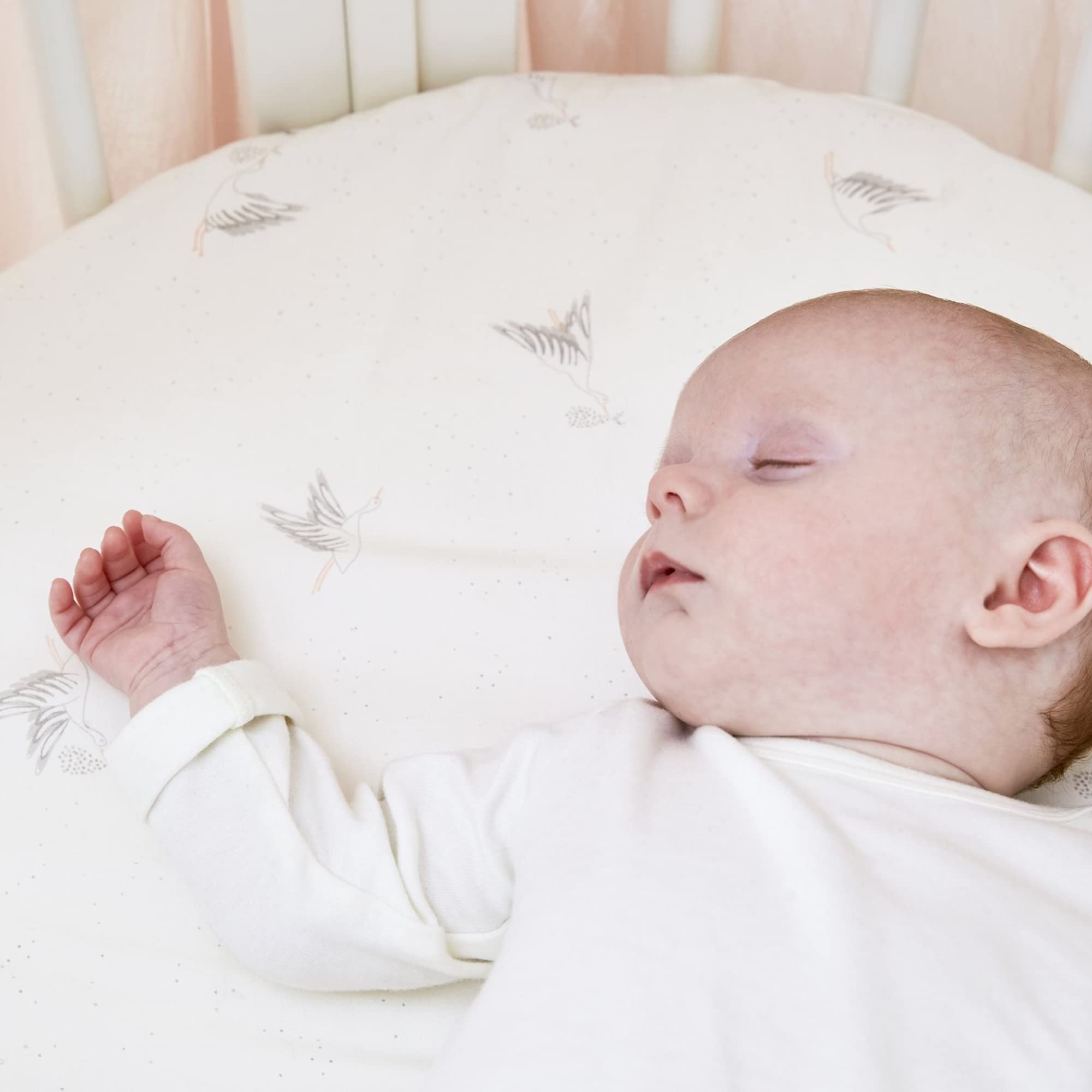 Stokke Sleepi Mini fitted sheet close-up shows soft organic cotton texture.