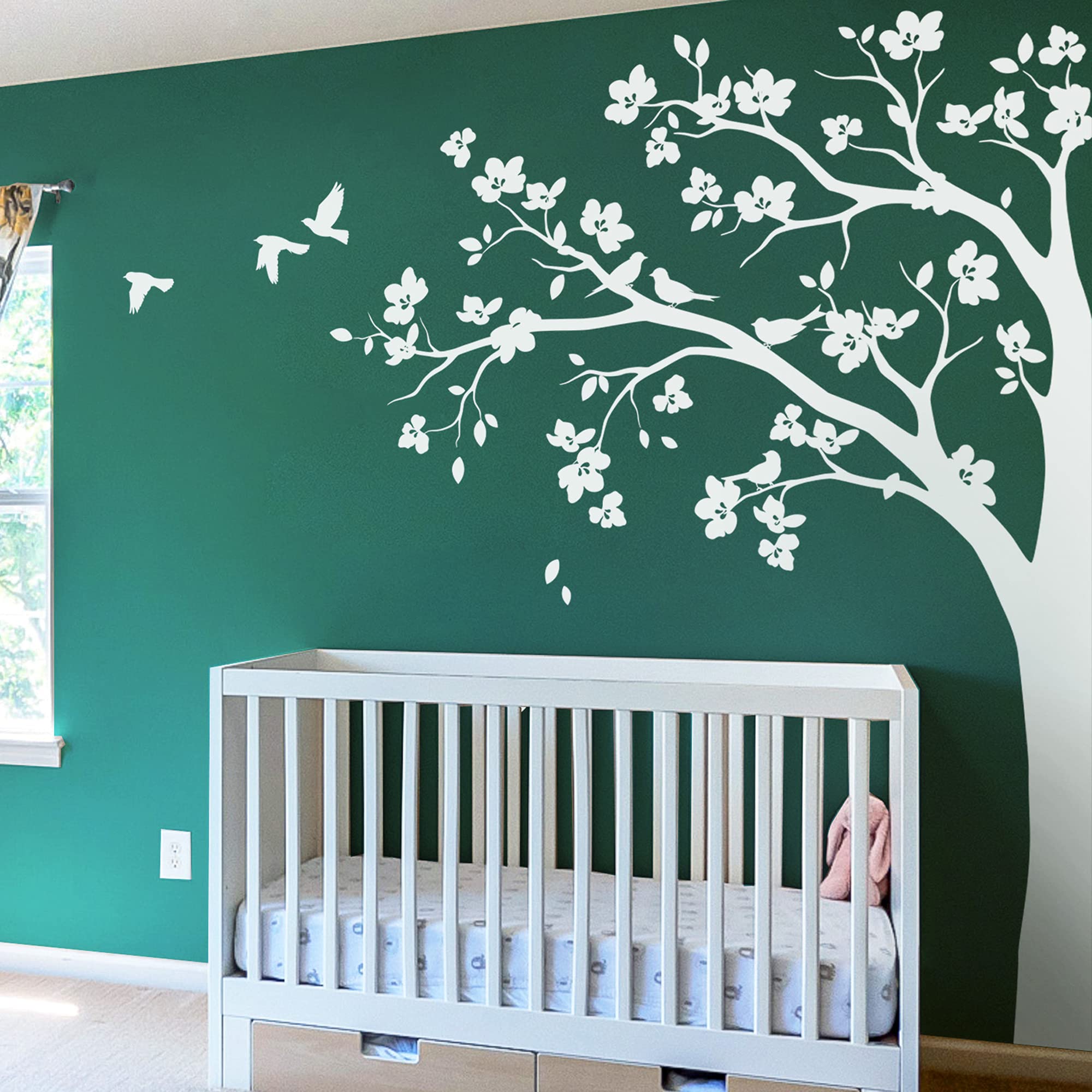 Studio Quee large corner tree wall decal with big blossoms and birds adds cozy, whimsical touch to nurseries.