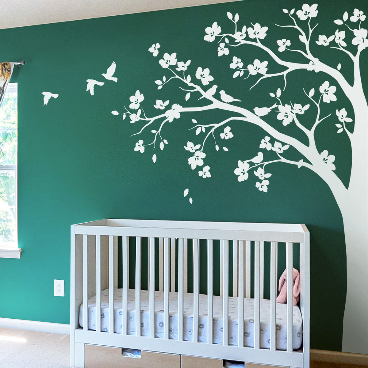 Studio Quee large corner tree wall decal with big blossoms and birds adds cozy, whimsical touch to nurseries.