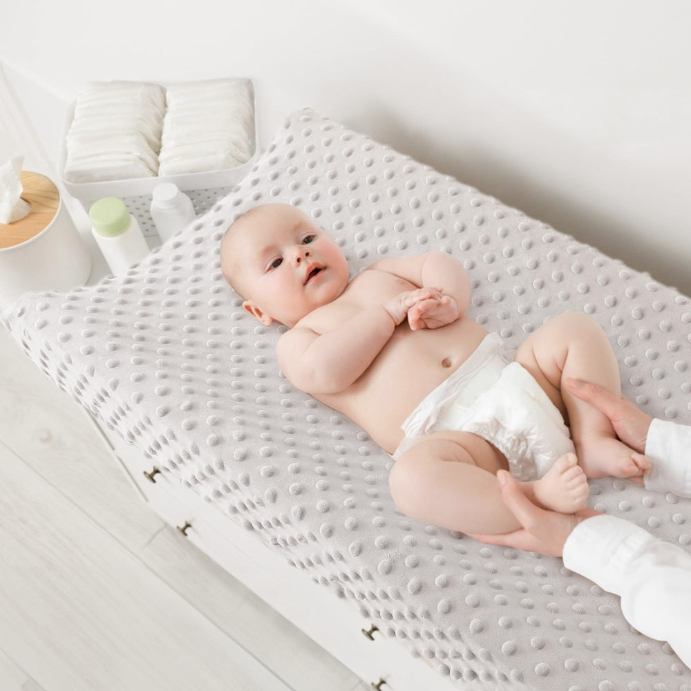 Susurration close-up of plush, breathable texture on changing pad cover.