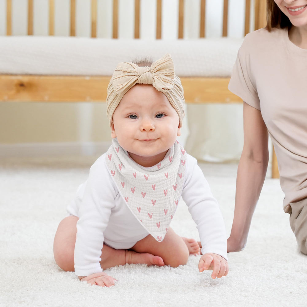 Susurration muslin baby bib soft absorbency highlighted in flatlay for daily drool relief.
