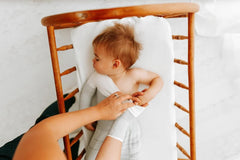 Swaddelini arms-out sleep sack grey worn by baby illustrates freedom and calm.