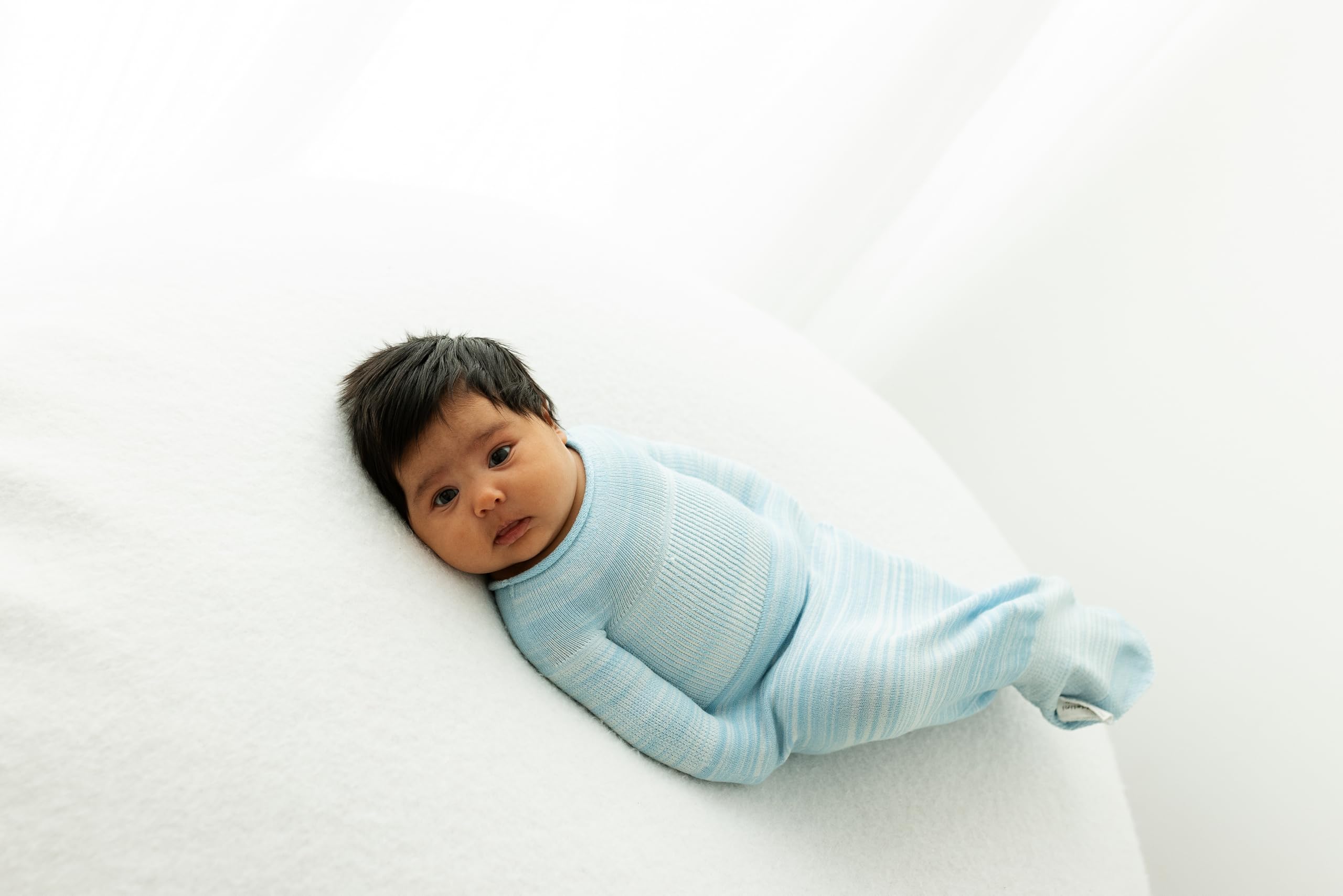 Swaddelini blue sleep sack in use promotes secure, comfortable sleep.