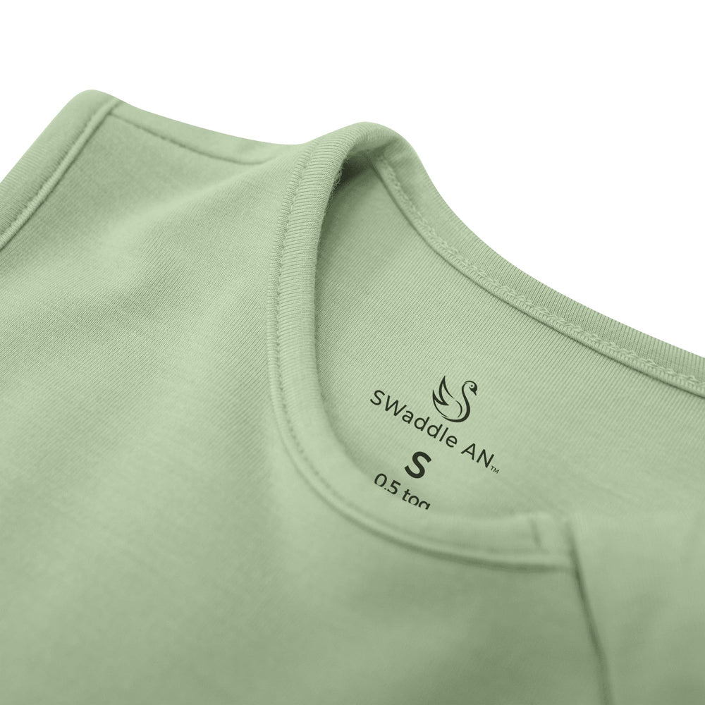 Model wearing the sage green SWaddle AN sleep bag in a unisex look