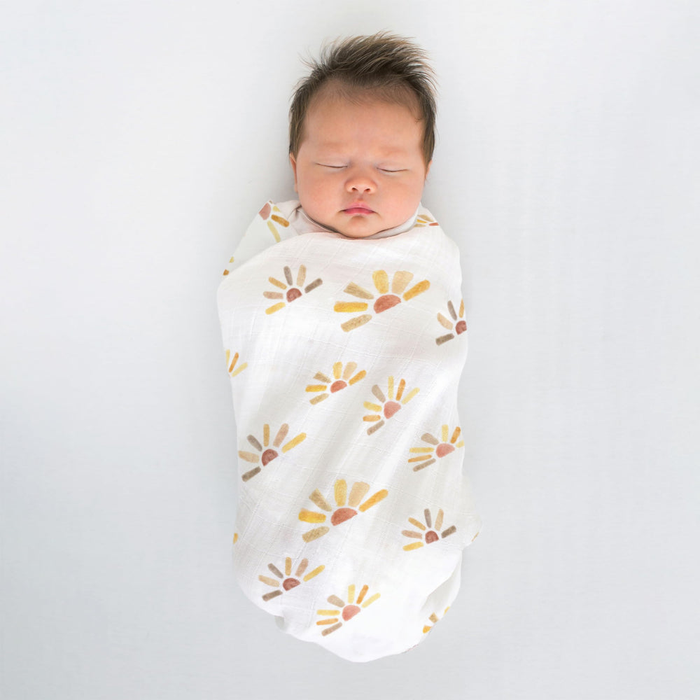 SwaddleDesigns machine washable muslin blanket shown in practical use