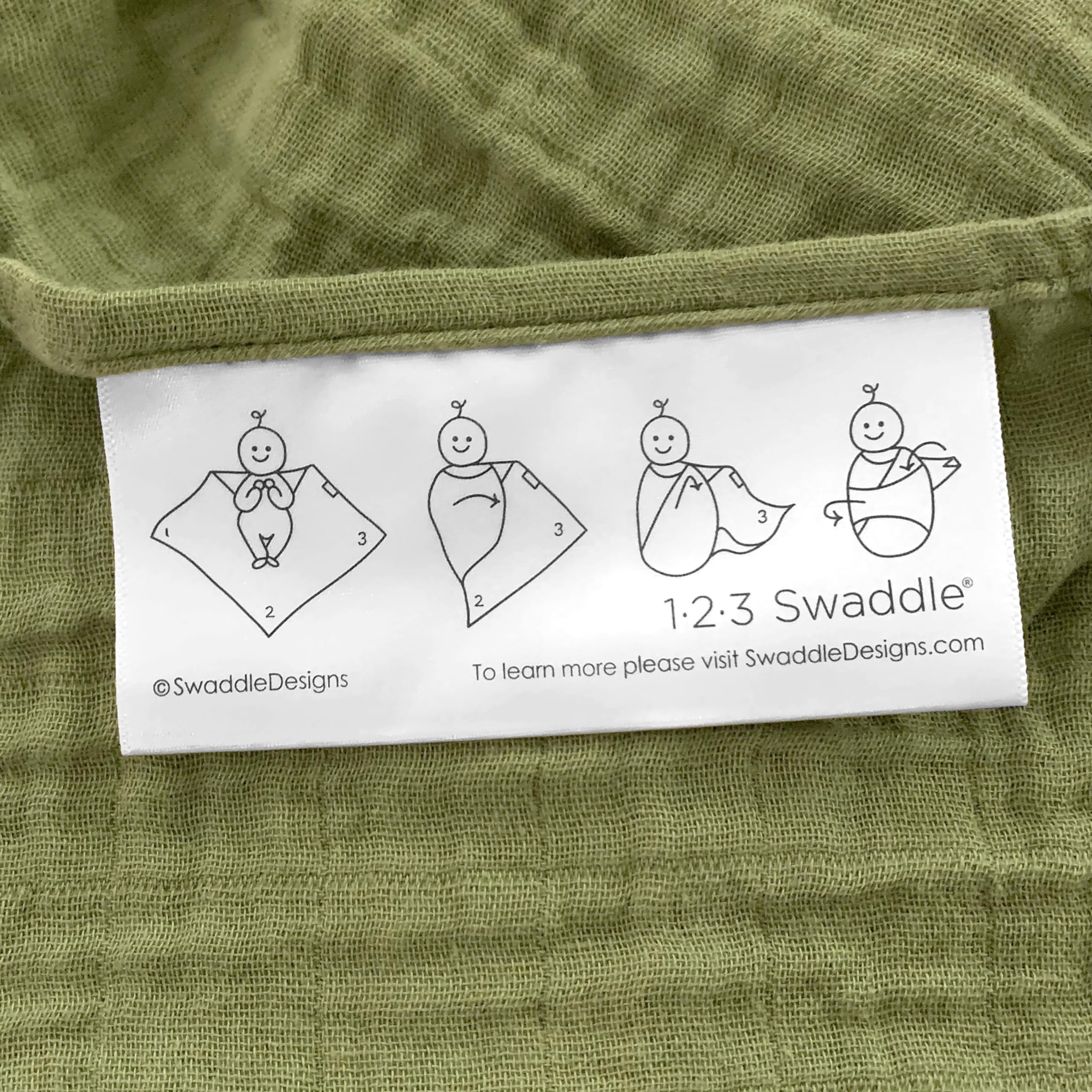 SwaddleDesigns blanket edge shows 123 Swaddle label with easy swaddling steps.