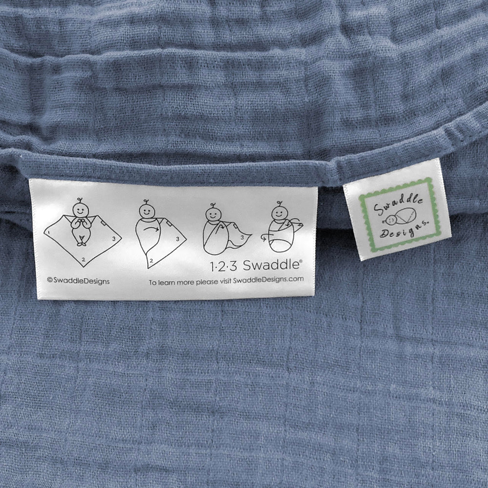 SwaddleDesigns denim muslin swaddle blanket with easy swaddle label.