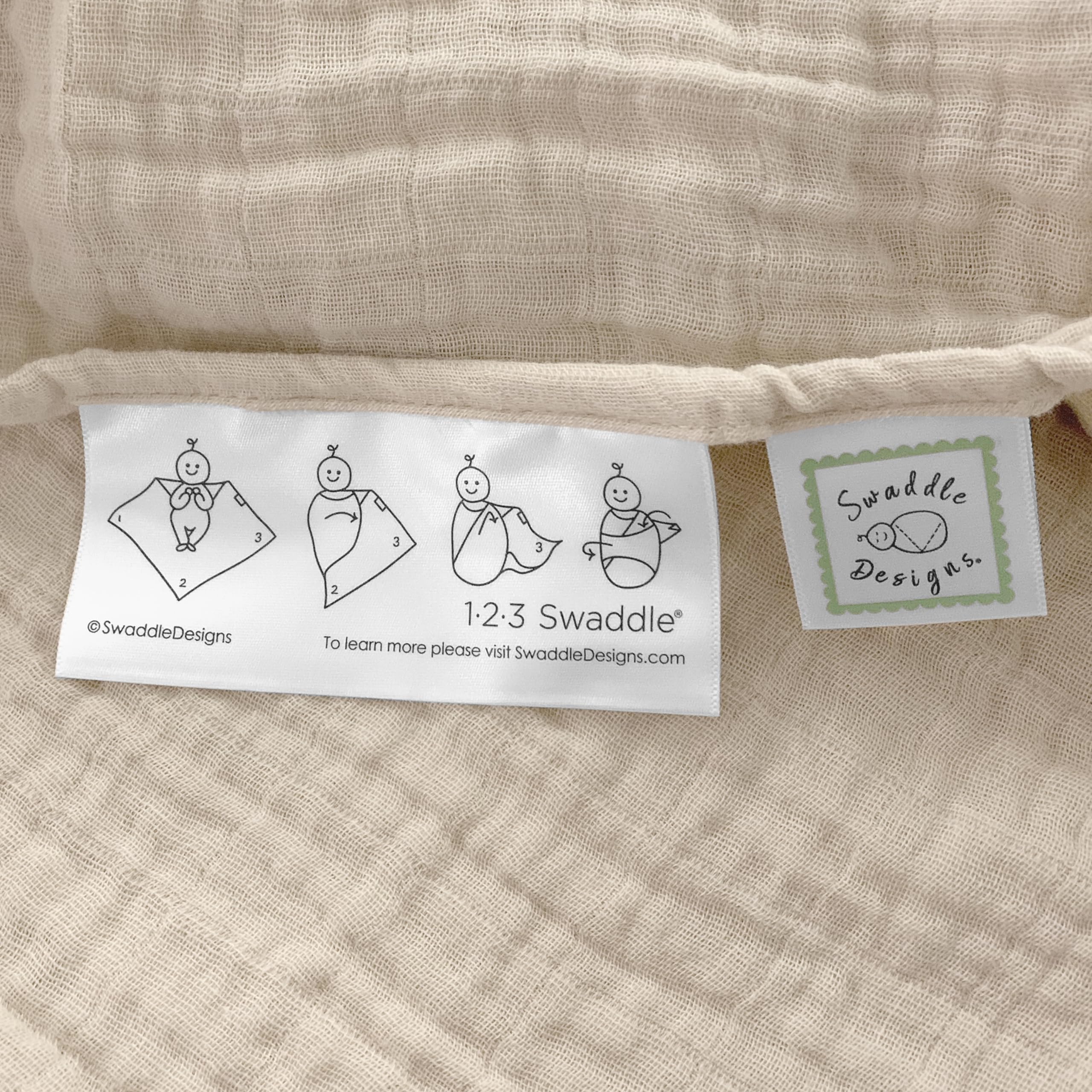 SwaddleDesigns oatmeal blanket edge features 123-swaddle-label for easy steps.
