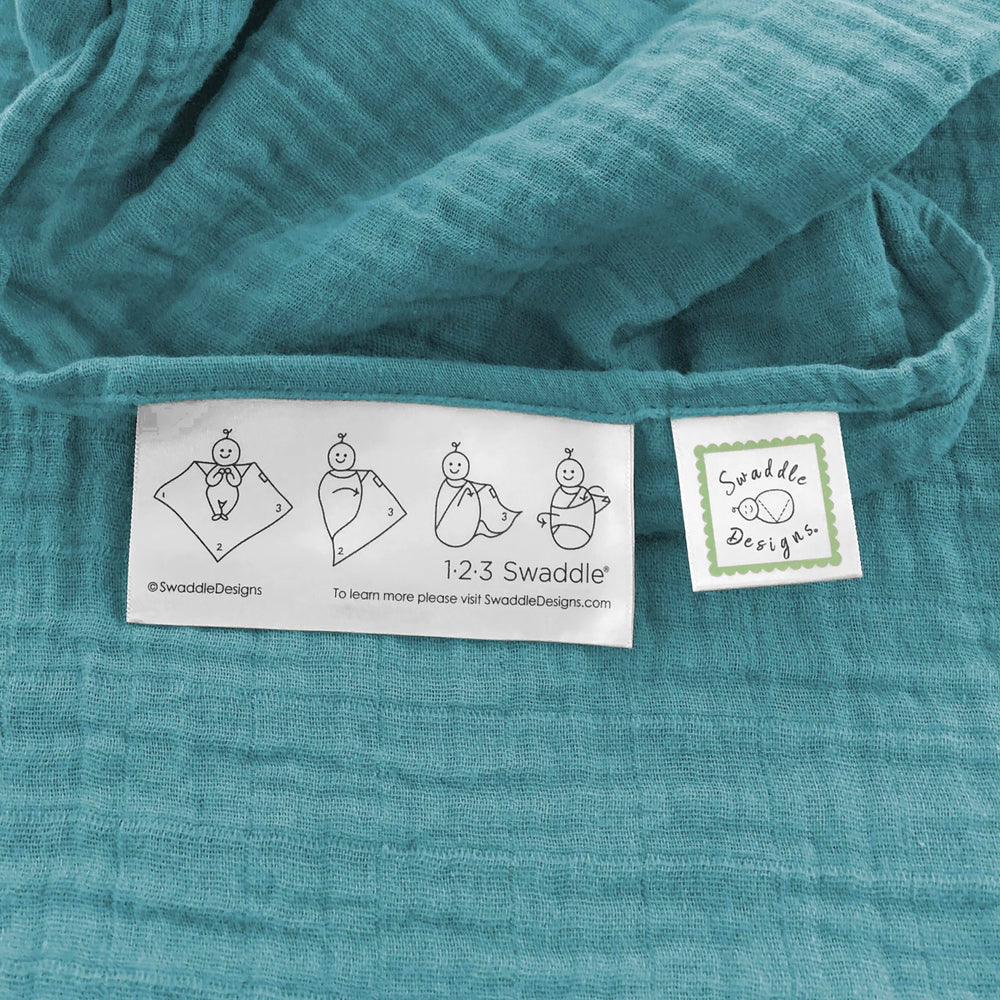 SwaddleDesigns teal cotton muslin blanket draped as sunshield on a stroller
