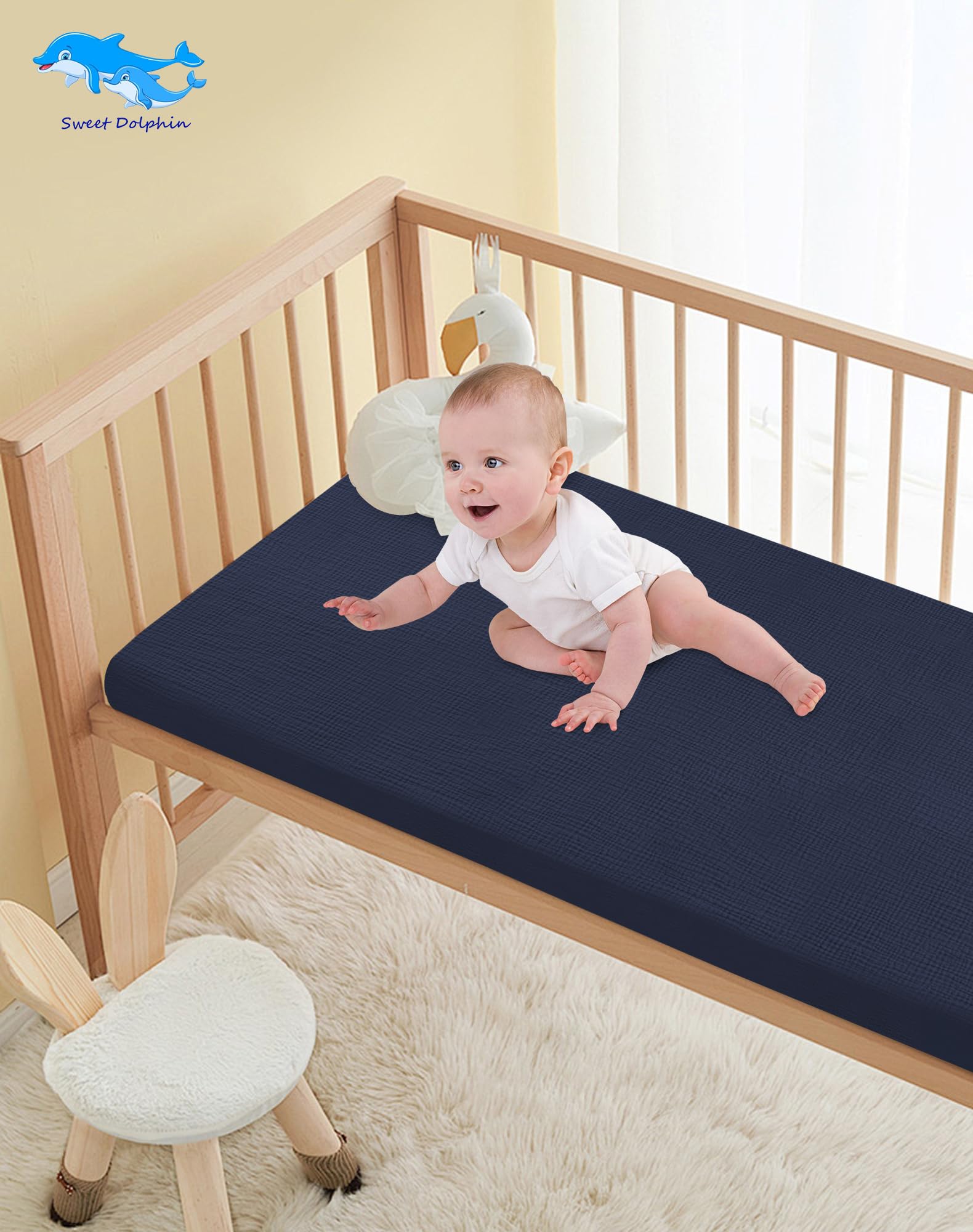 Machine-washable Sweet Dolphin crib sheets shown in laundry setting