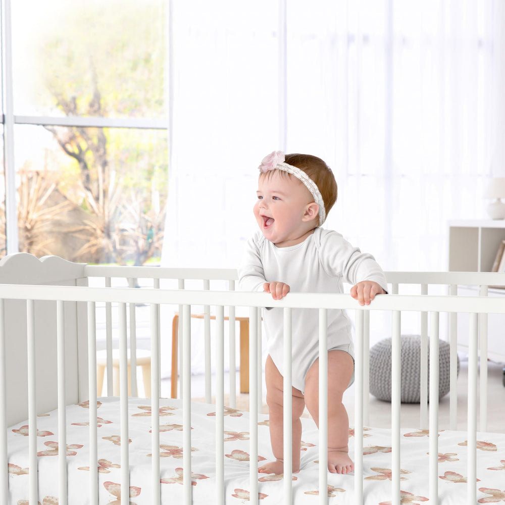 Sweet Jojo Designs crib sheet folded on bed showing snug fit and softness.