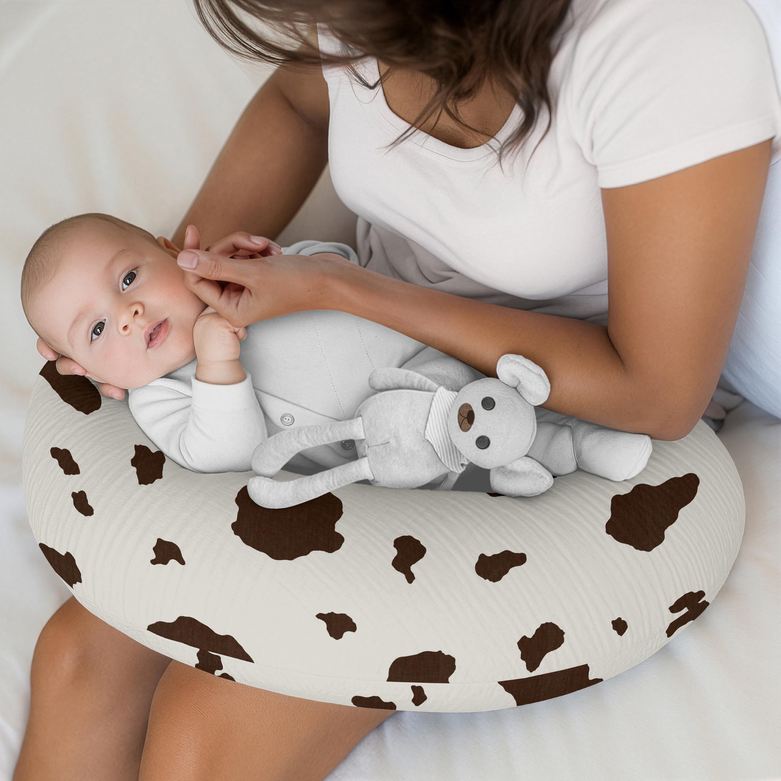 Sweet Jojo Designs muslin pillow cover on a bed with western cow print coordinating nursery decor.