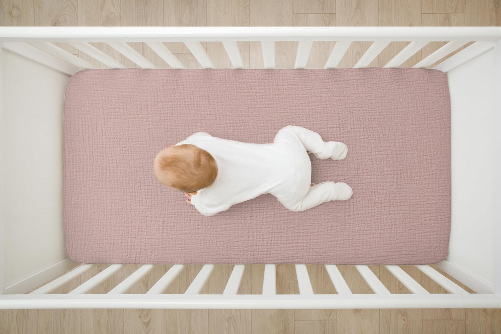 TADO MUSLIN 52x28 crib mattress fit image demonstrates precise, deep pockets.