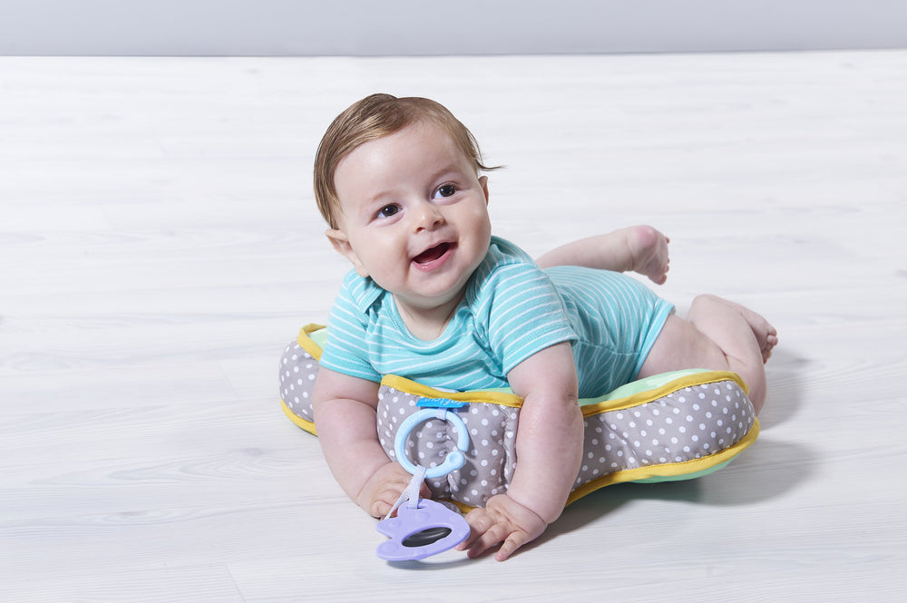 Taf Toys tummy time cushion demonstrates ergonomic chest support for gentle lifting.