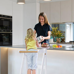 TDKDHoming foldable-toddler-tower in use for independent cooking tasks