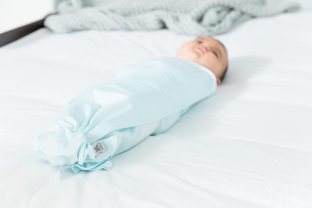 The Ollie Swaddle safe-sleep scene emphasizes calm bedtime routines.