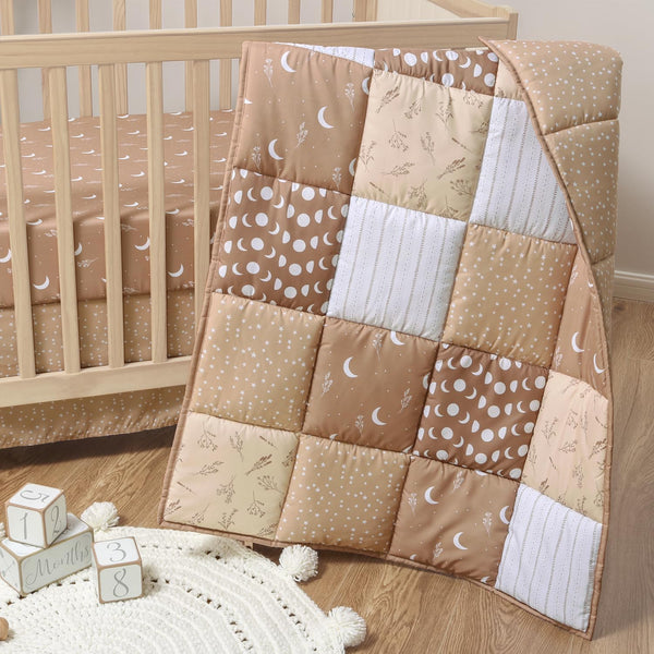 The Peanutshell celestial crib bedding quilt with stars adds cozy charm to the nursery.