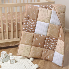 The Peanutshell celestial crib bedding quilt with stars adds cozy charm to the nursery.