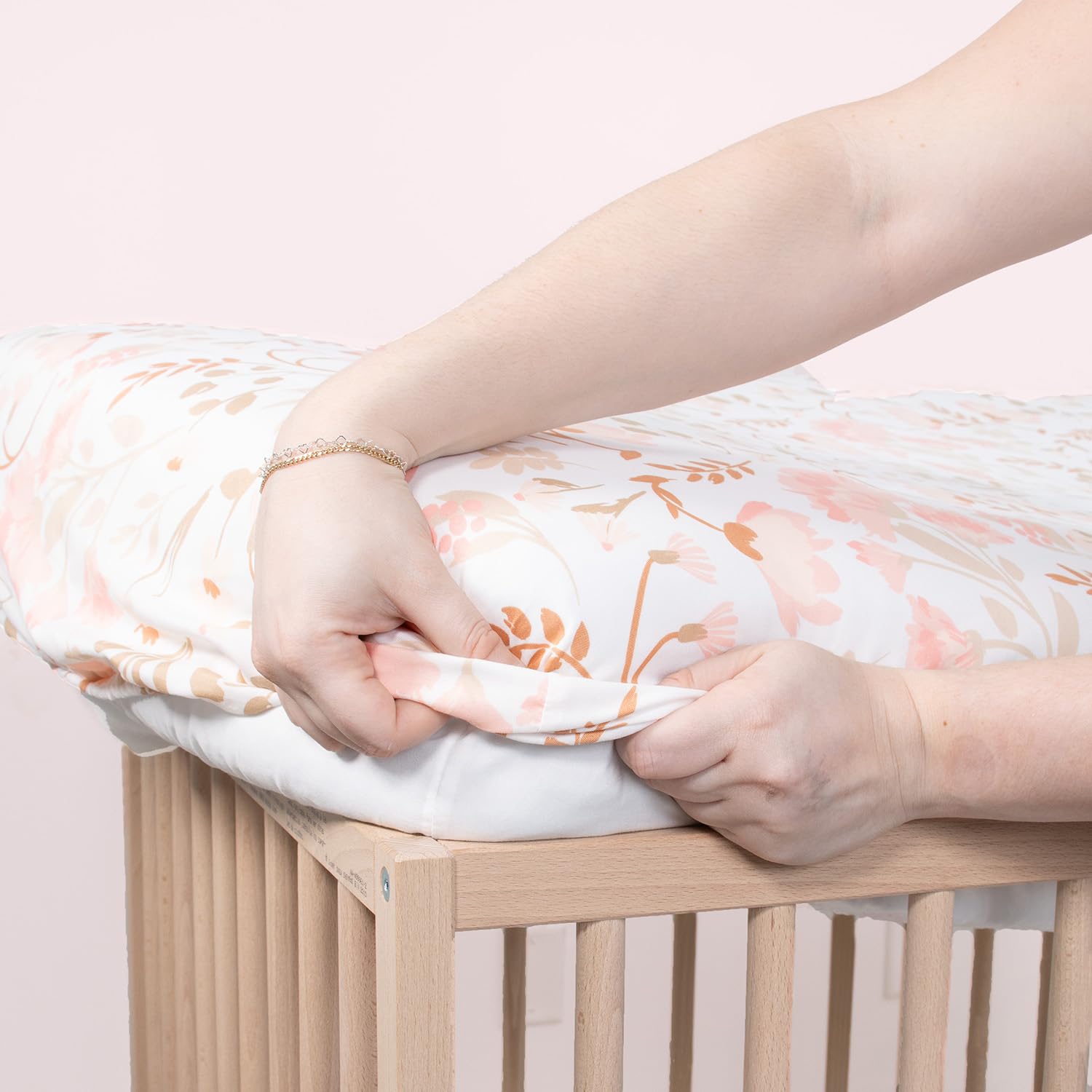 The Peanutshell whimsical-pink-beige-sheets add charming nursery decor.