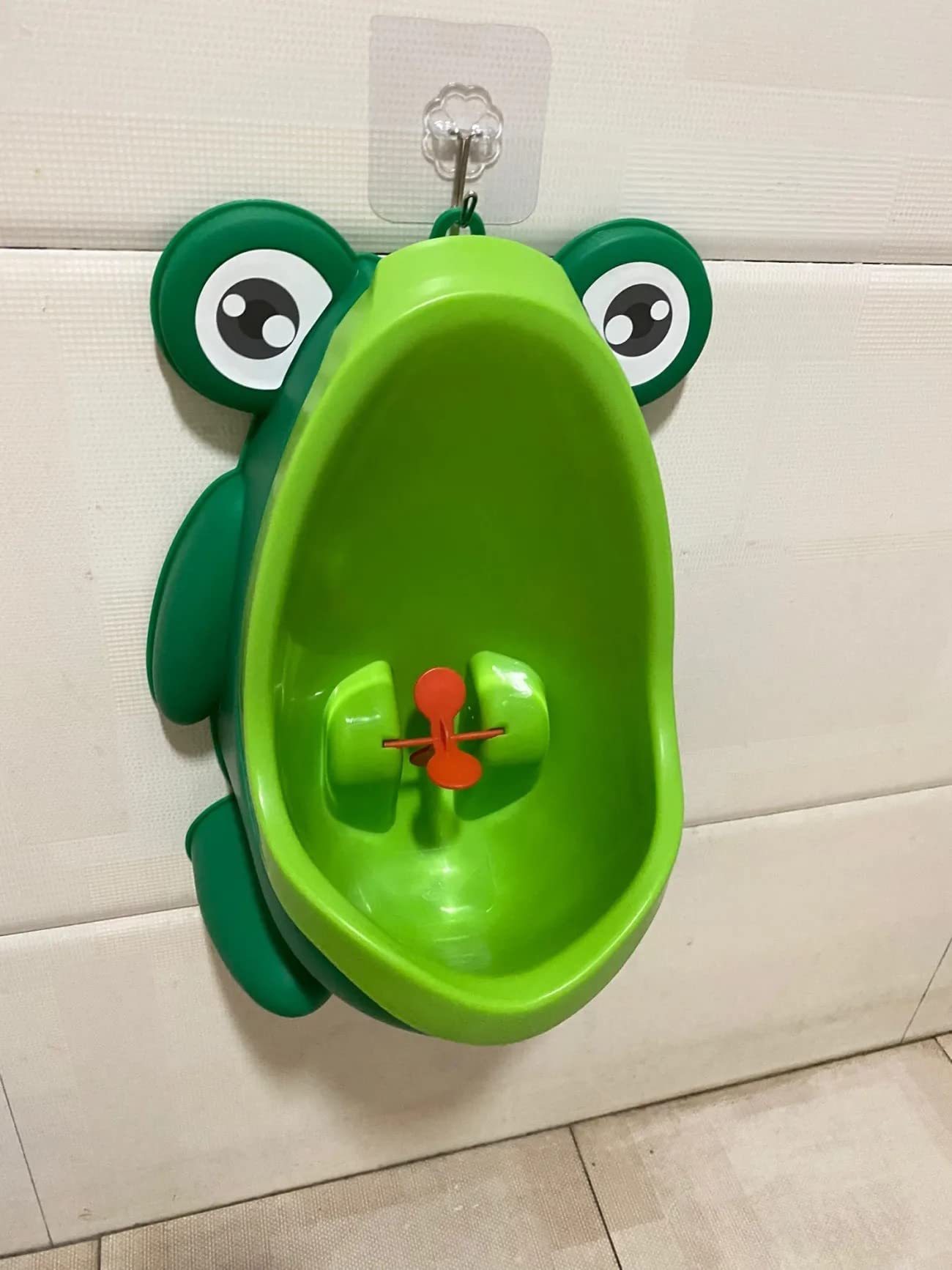 Tikono frog design potty urinal mounted on wall for secure placement.