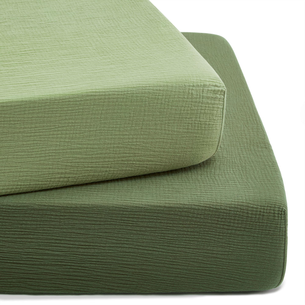 TILLYOU forest green muslin crib sheet on a standard crib mattress, soft and breathable