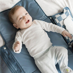 Tiny Twinkle changing pad attached to a stroller via clip for hands-free use.