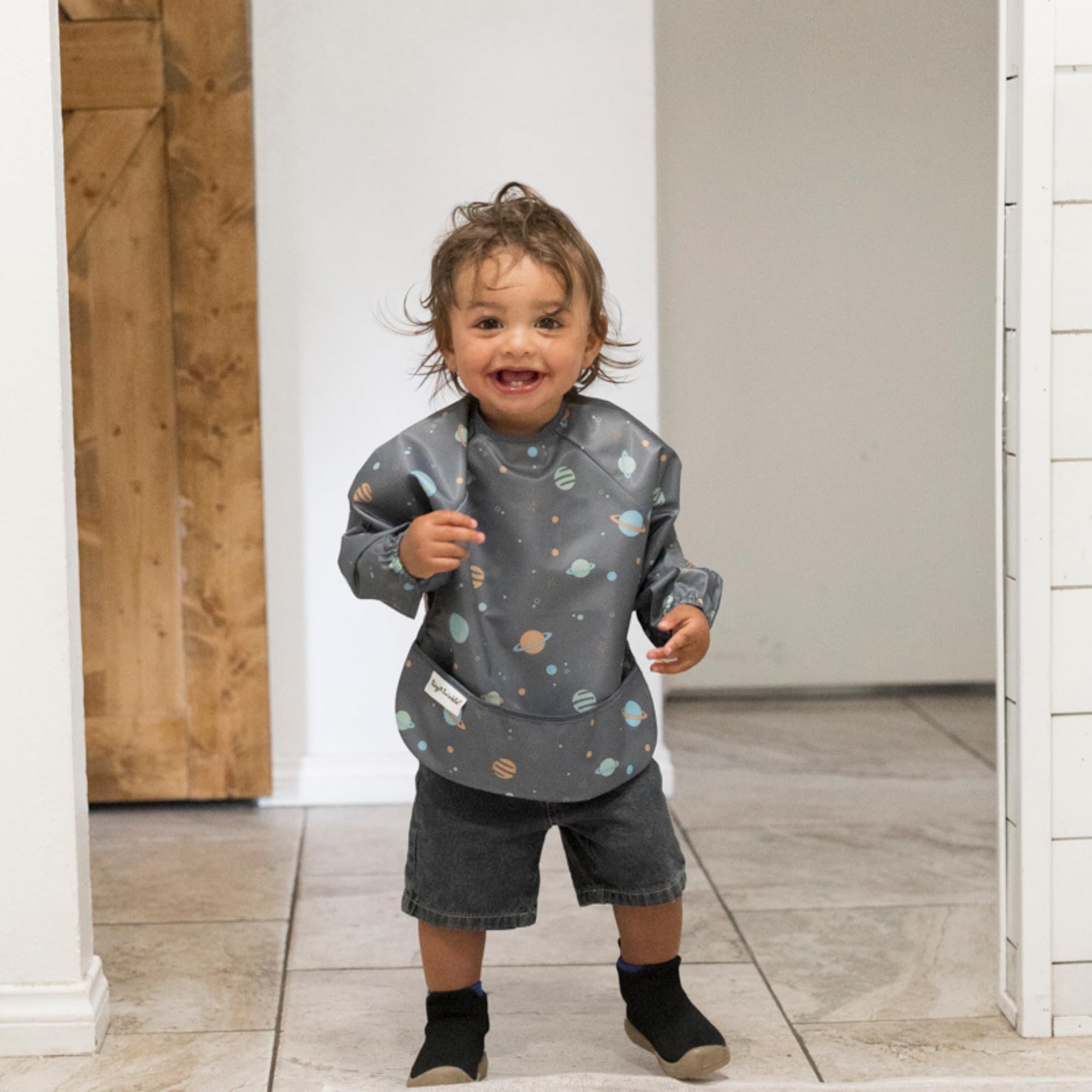 Tiny Twinkle long-sleeve bib laid flat highlights machine-washable material.