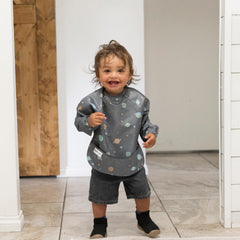 Tiny Twinkle long-sleeve bib laid flat highlights machine-washable material.