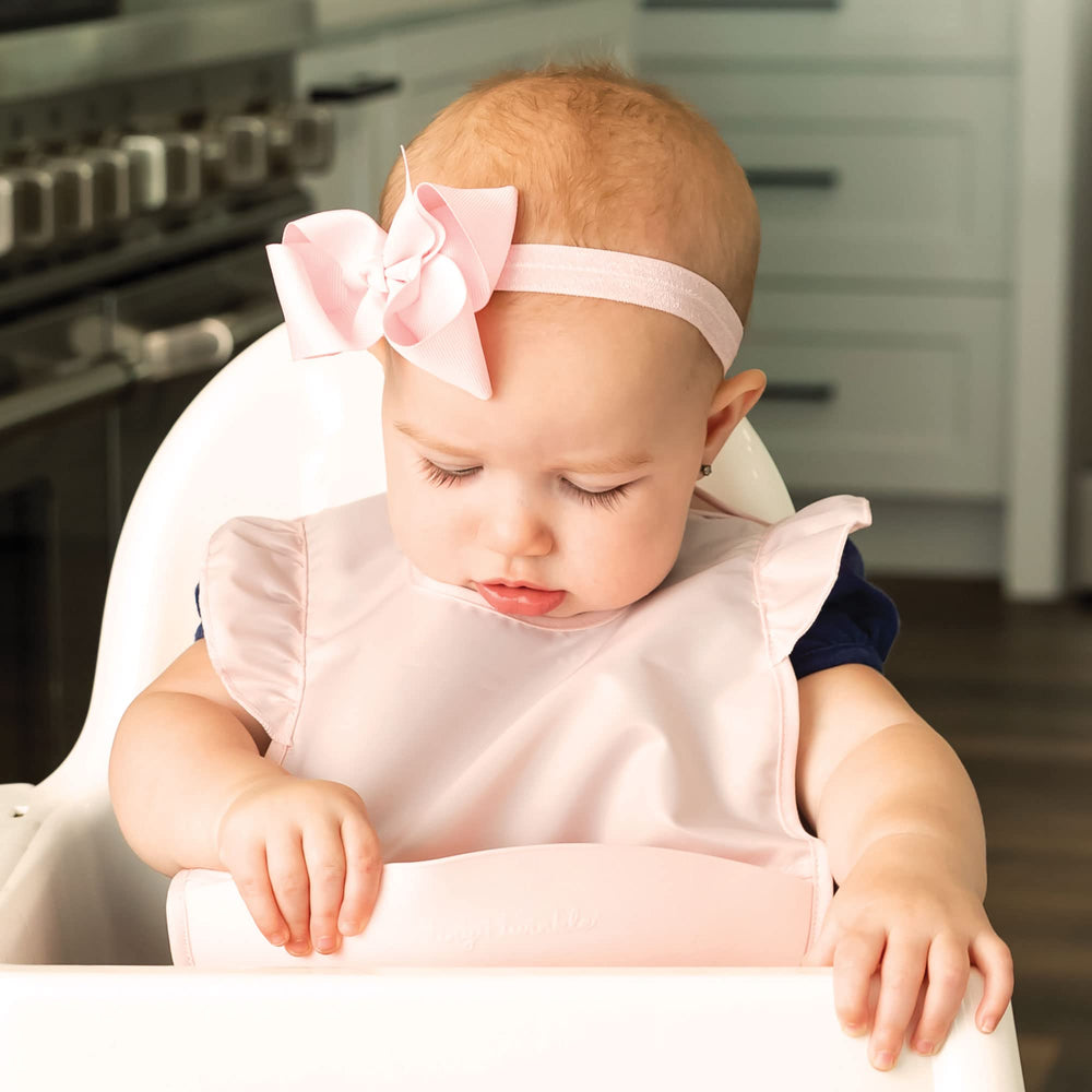 Tiny Twinkle silicone bib travel-pod folds into a compact case for restaurant outings.