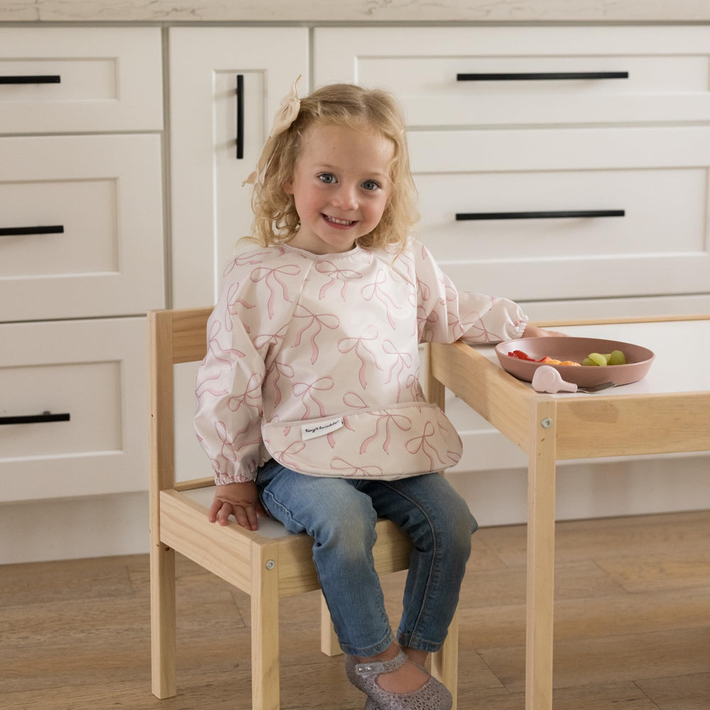 Tiny Twinkle waterproof smock bib protects clothing through messy snacks.