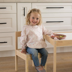 Tiny Twinkle waterproof smock bib protects clothing through messy snacks.