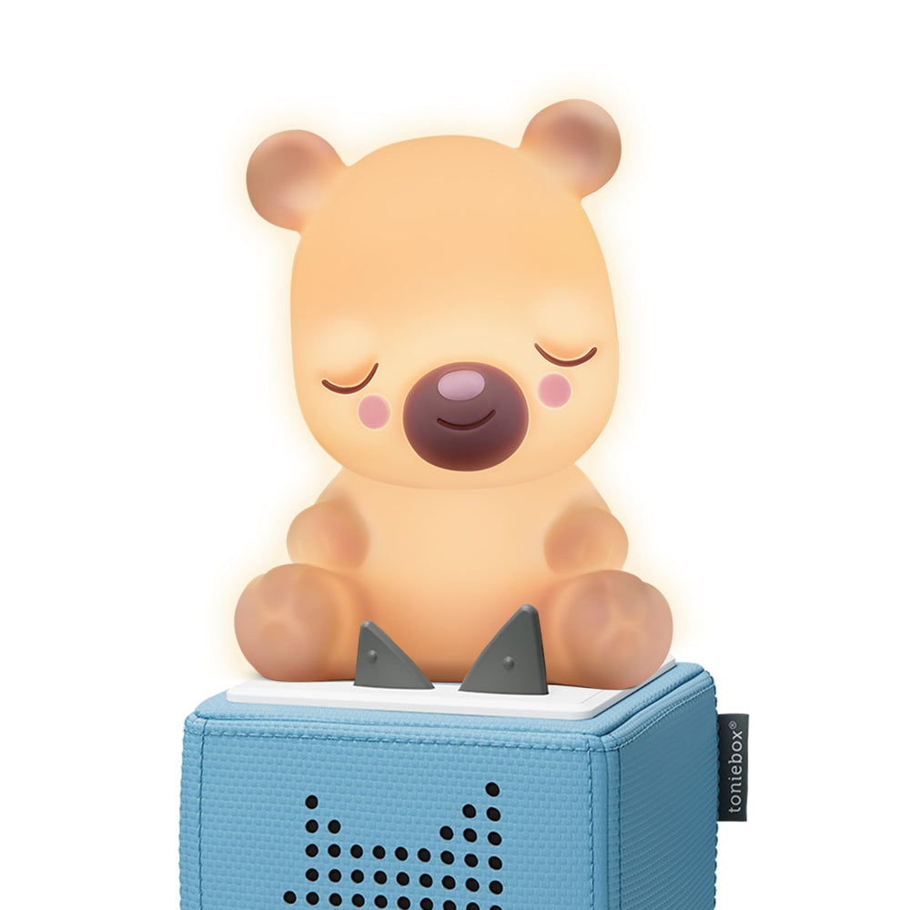 Tonies Sleepy Bear Night Light glows softly beside a Toniebox for calmer bedtimes.