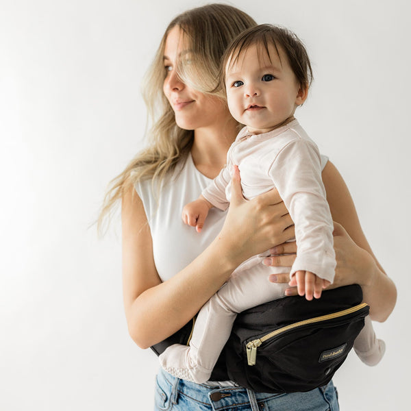 The TushBaby Original hip-seat front view demonstrates ergonomic support during carries.